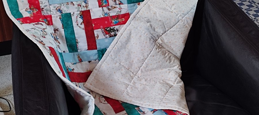 un baby quilt avec du tissu sur le thême de Peter Rabbit